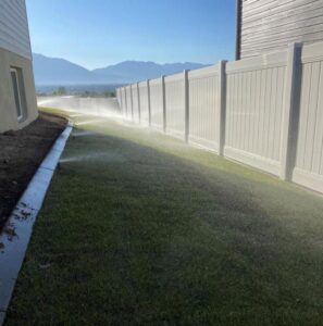 multiple sprinklers watering grass