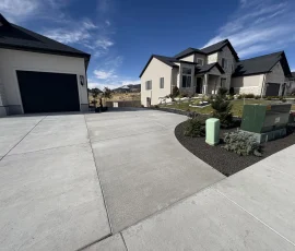 Two modern suburban homes with concrete driveways and small landscaped front yards.